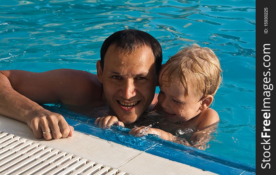 A father and his son have fun in the pool. A father and his son have fun in the pool