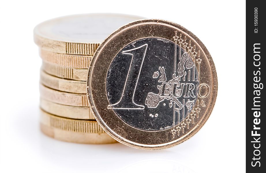 One euro coin in front of a stack of Euro coins. One euro coin in front of a stack of Euro coins.