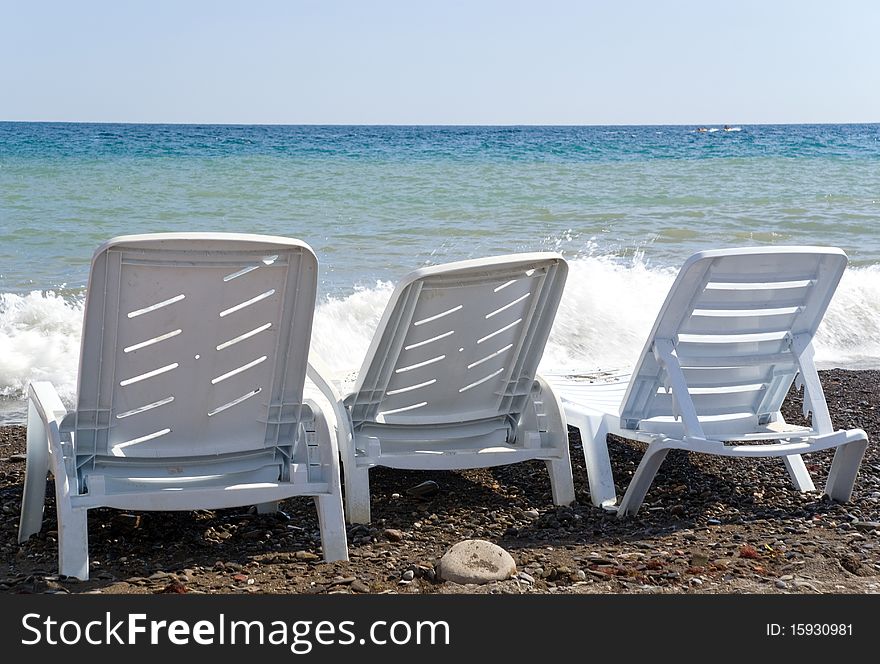 Three beach chairs against breaker