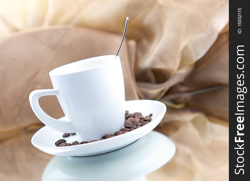 Coffee cup with beans against brown background