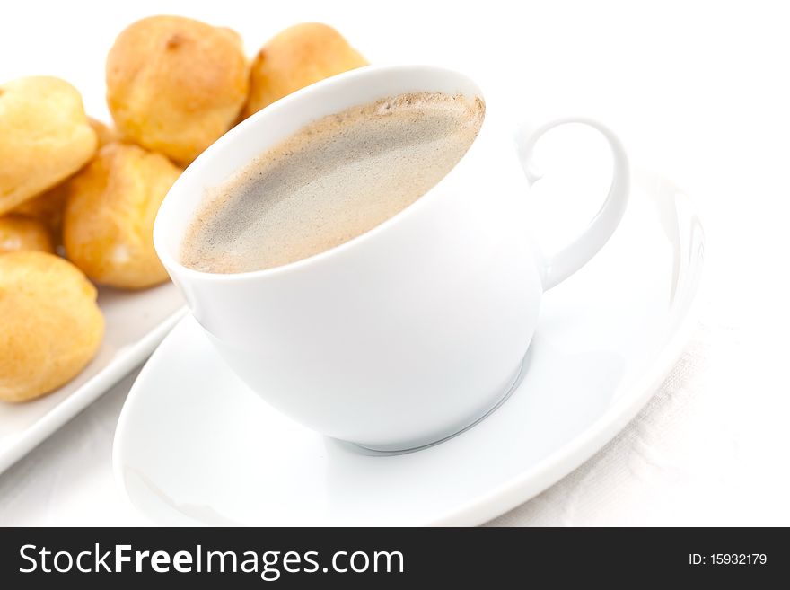 Coffee and cream puff on table