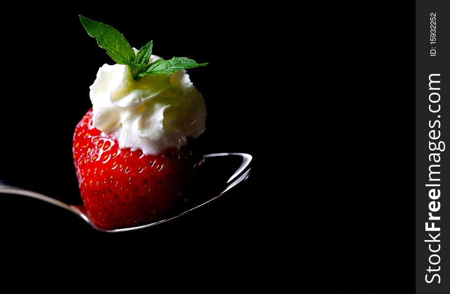 Strawberry with cream and mint on spoon