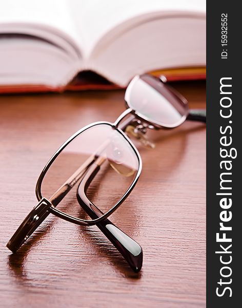 Glasses close up and the open book on a background. Glasses close up and the open book on a background