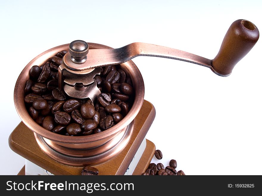 Clouse-up of ancient coffee grinder with coffee grains