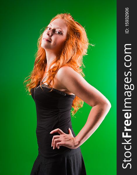 Beautiful red-haired woman with a worried look in black sarafan on a green background. Beautiful red-haired woman with a worried look in black sarafan on a green background