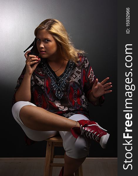 Young attractive woman holding shoe like a phone. Young attractive woman holding shoe like a phone.