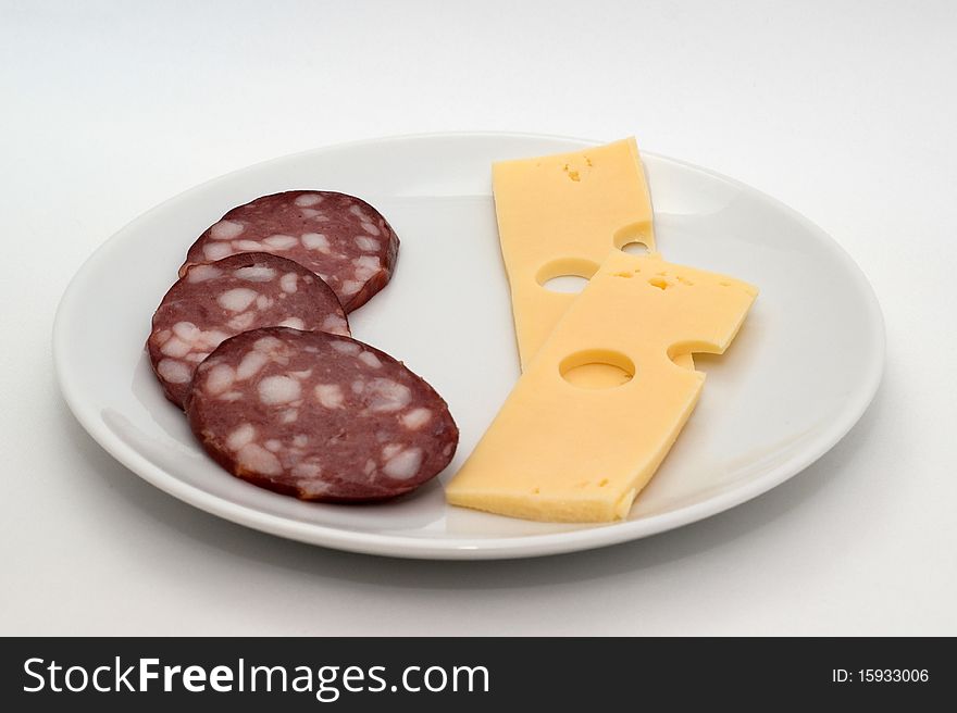 Sausage and cheese on a plate on a white background