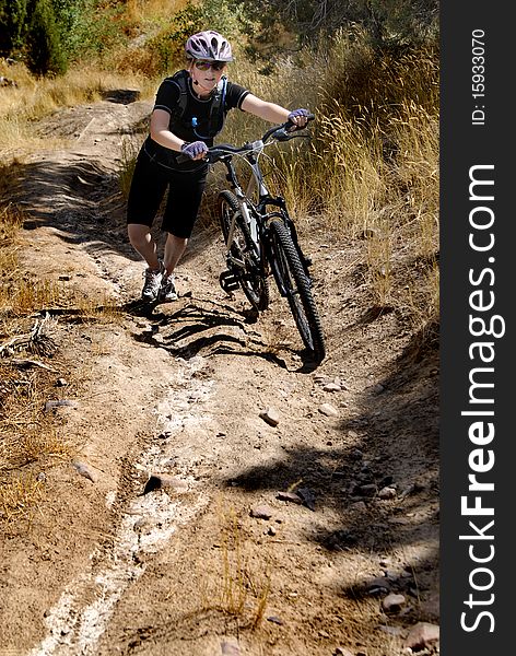 Young Woman Riding Mountain Bike in Wilderness. Young Woman Riding Mountain Bike in Wilderness