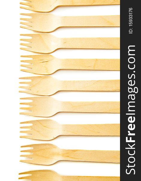 Wooden forks lined up and isolated on a white background