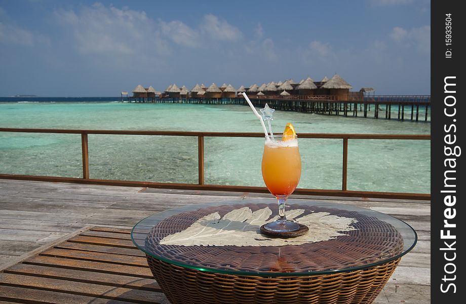 Orange cocktail with ocean at the background