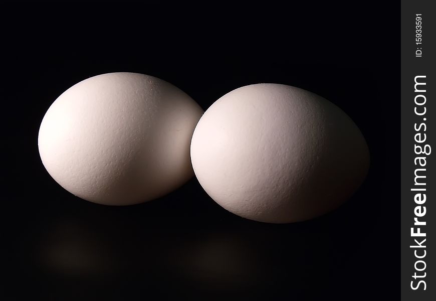 Two eggs on black background