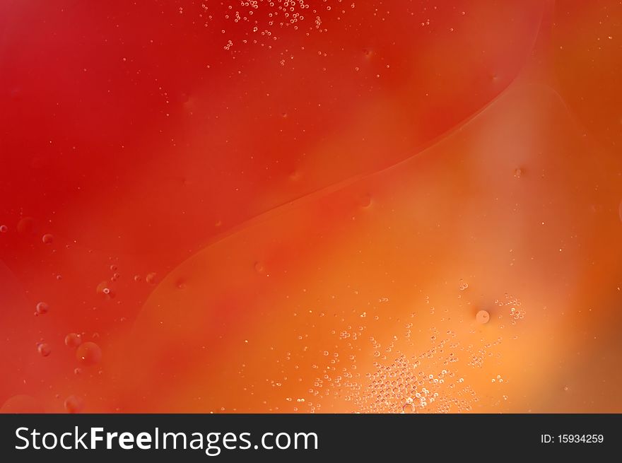 Macro image of oil in water with a colored background. Macro image of oil in water with a colored background