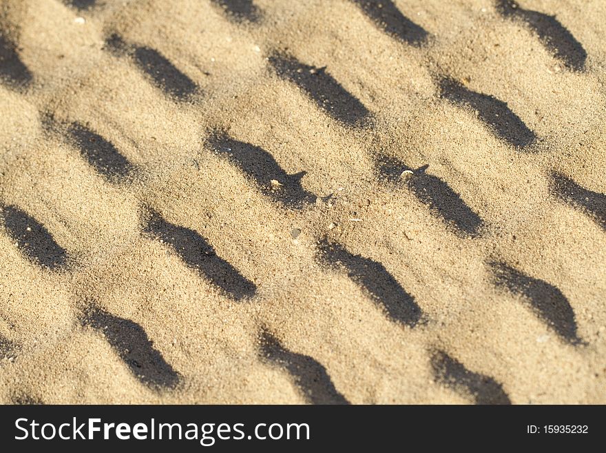 Background of pattern in the sand, regular intervals and slanted across the image