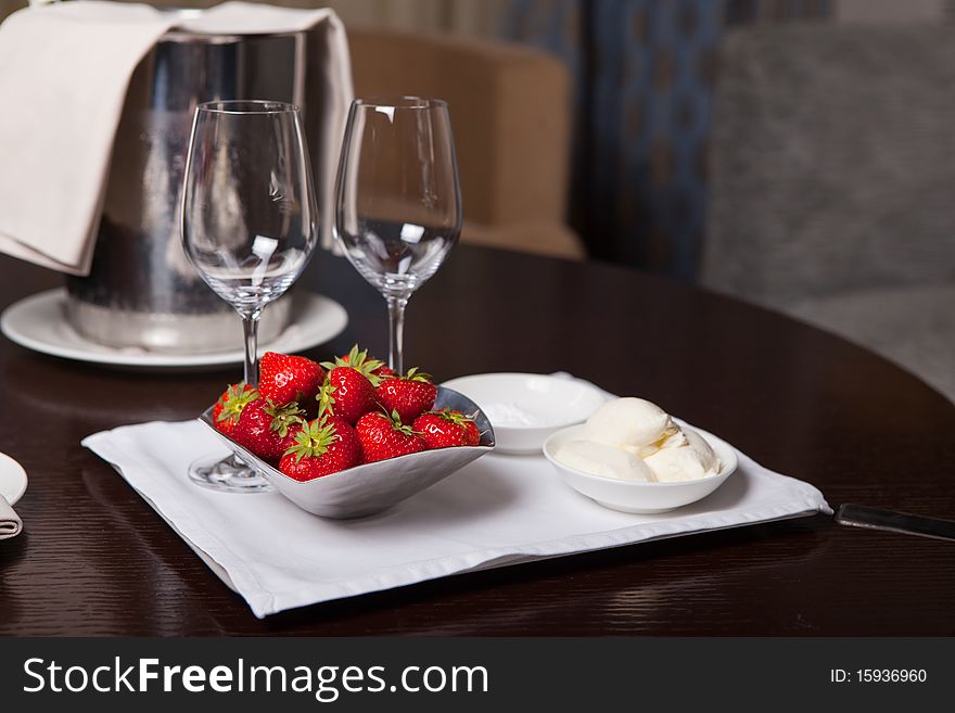 Two glasses for champagne and bunch of fresh strawberry at the table