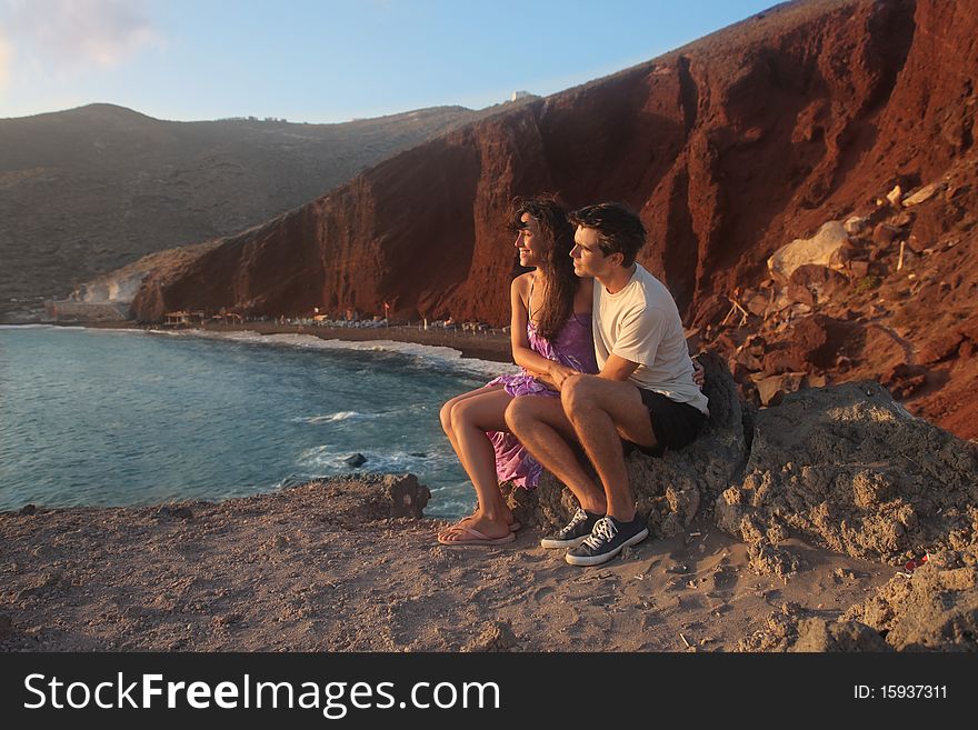 Young couple lokking at a sunset on the beach. Young couple lokking at a sunset on the beach
