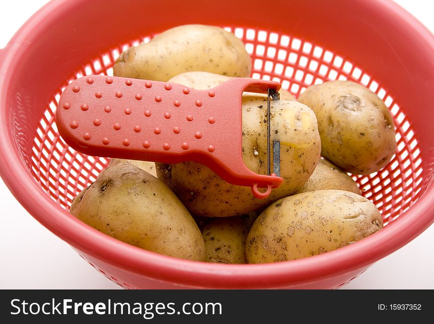 Raw potatoes in the kitchen sieve. Raw potatoes in the kitchen sieve