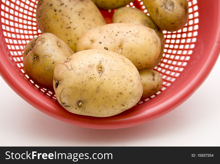 Raw potatoes in the kitchen sieve. Raw potatoes in the kitchen sieve