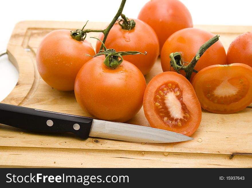 Tomatoes cut onto edge board with knife