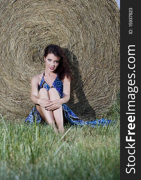 Young beautiful girl near haystacks