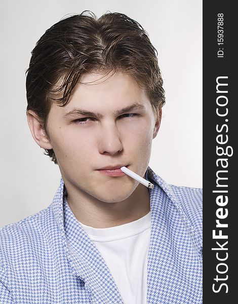 A portrait of a young sexy man smoking a cigarette