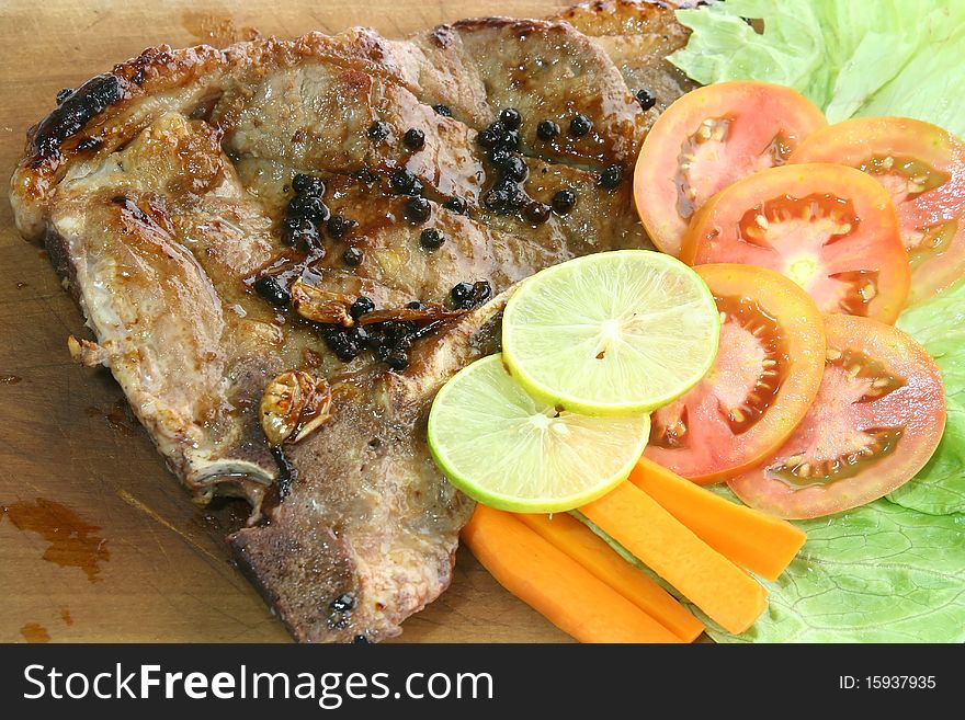 T Bone Pepper Steak with vegetable on Wooden board