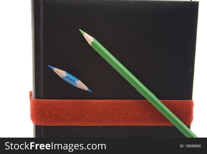 Colored pencils on book with bow. Colored pencils on book with bow