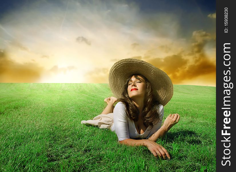 Beautiful woman lying on a green meadow in the sun. Beautiful woman lying on a green meadow in the sun