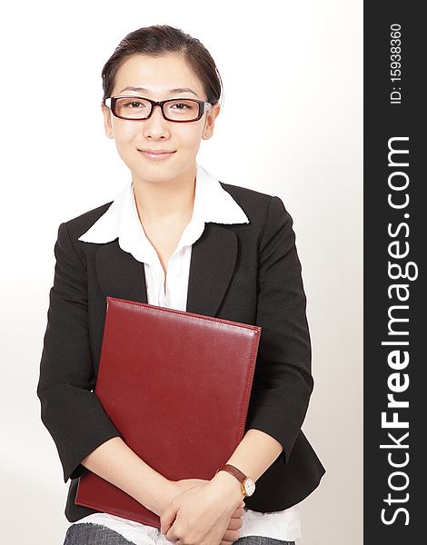 A smiling business woman holding a file. A smiling business woman holding a file.
