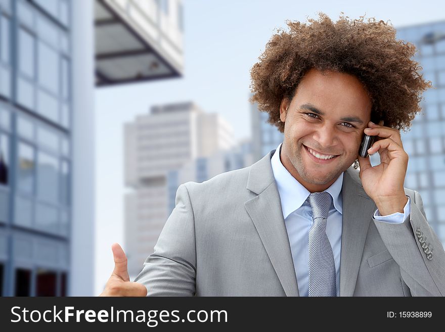 Businessman on the phone in front of modern building. Businessman on the phone in front of modern building