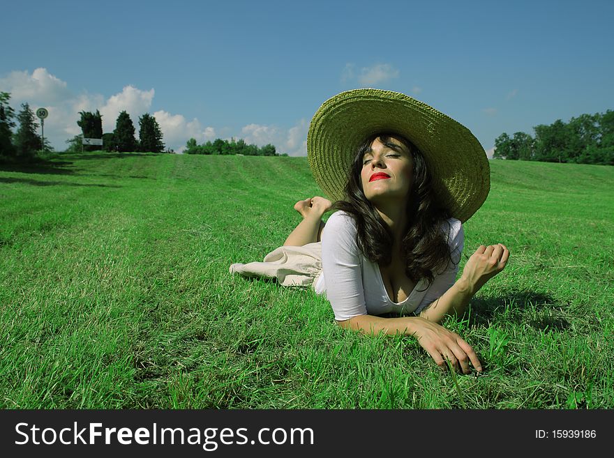 Beautiful woman lying on a green meadow and smiling to the sun. Beautiful woman lying on a green meadow and smiling to the sun