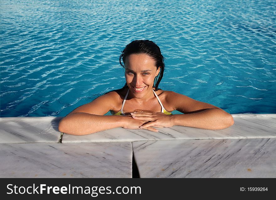 Smiling beautiful woman in a swimming pool. Smiling beautiful woman in a swimming pool