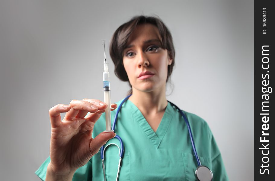 Female doctor holding a syringe. Female doctor holding a syringe