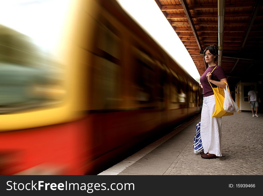 Young woman standing on the platform of a train station. Young woman standing on the platform of a train station