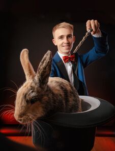 A Young Guy Magician Illusionist Holding A Hat With A Rabbit Royalty Free Stock Photo A Young Guy Magician Illusionist Holding A Hat With A Rabbit Royalty Free Stock Photo