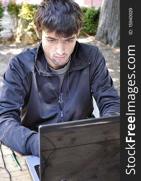 Young man working on his computer outdoor