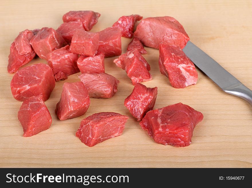Pieces of beef tips on a cutting board. Pieces of beef tips on a cutting board
