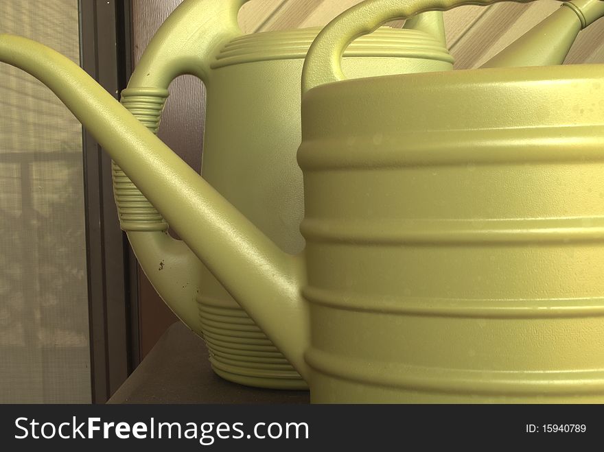 Two watering cans on the porch