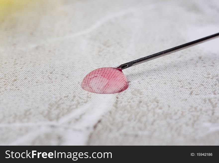 Pink spill from a syringe on a gray background.