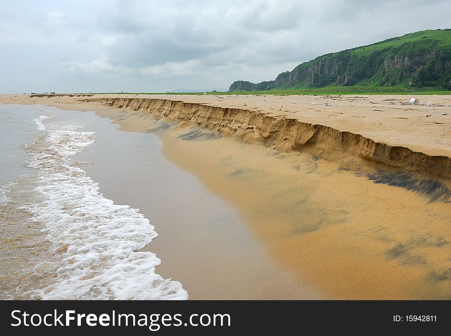 Sand beach view with wavy sea and cloudy sky. Sand beach view with wavy sea and cloudy sky