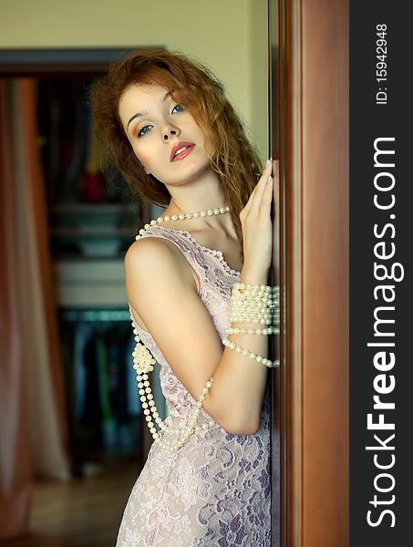 Beautiful woman, adorned with pearls, standing at the door. Beautiful woman, adorned with pearls, standing at the door.