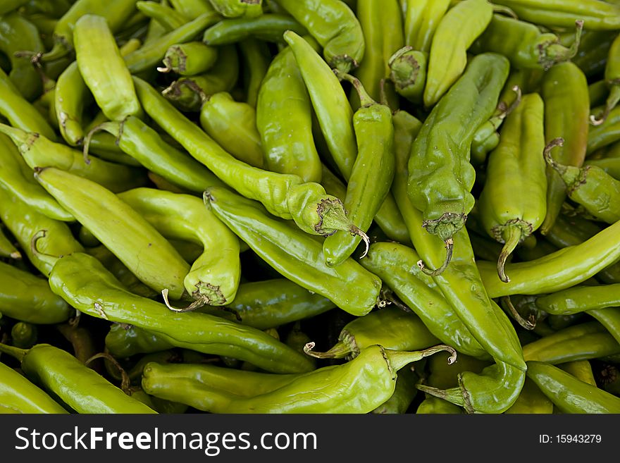 A large group of hot green chili peppers isolated in a horizontal format. A large group of hot green chili peppers isolated in a horizontal format.