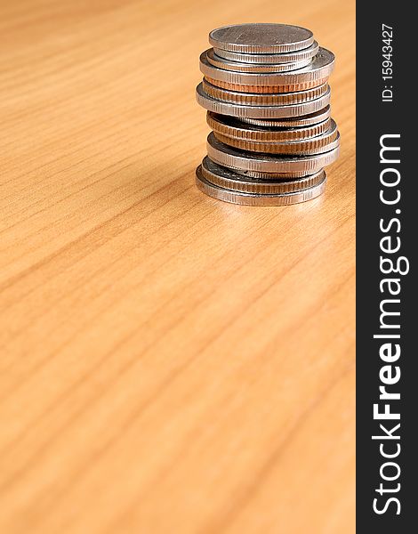 Column of coins on brown wooden table. Column of coins on brown wooden table