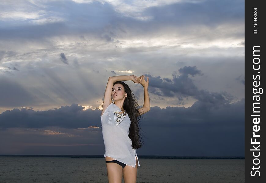 brunette woman over dusk sky at sunset