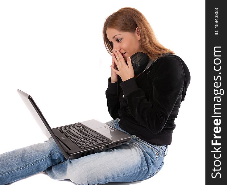 Surprised young woman  with headphones and laptop,isolated on white