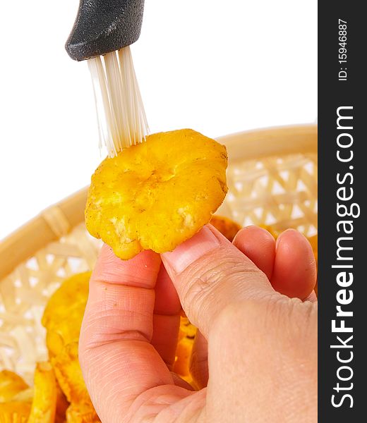 Hand cleaning fresh chanterelle mushroom.