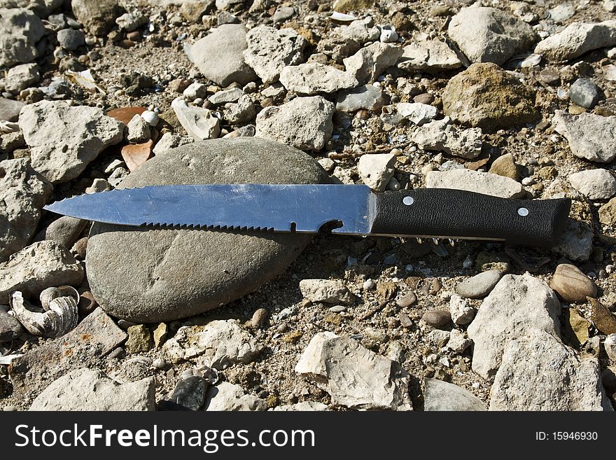 Knife lying on the stones without the cover. Knife lying on the stones without the cover