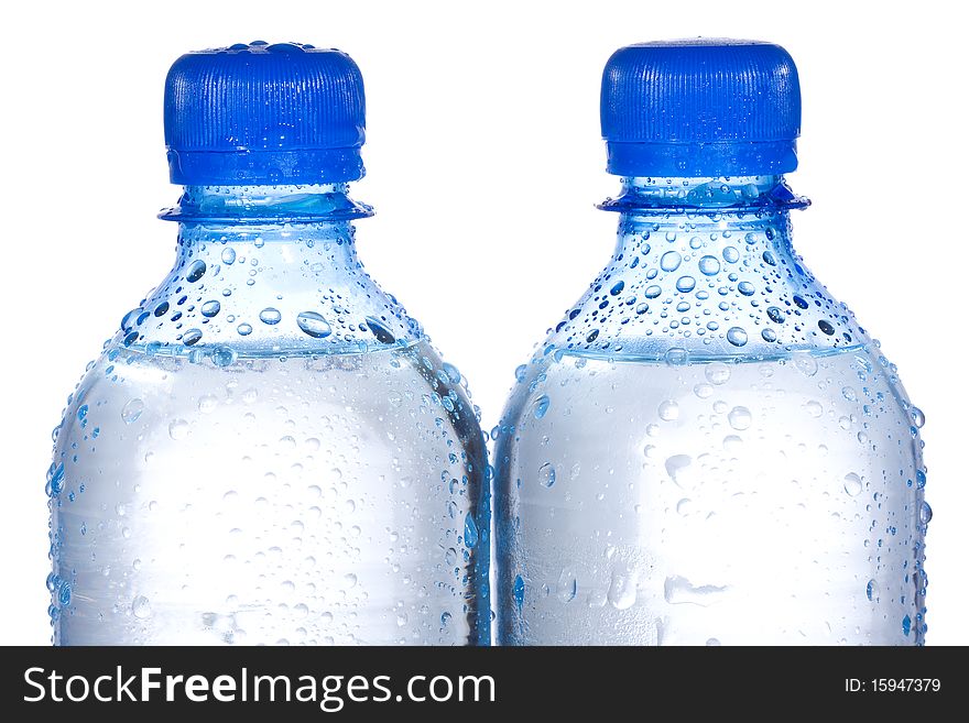 Plastic bottles with water drops on white background