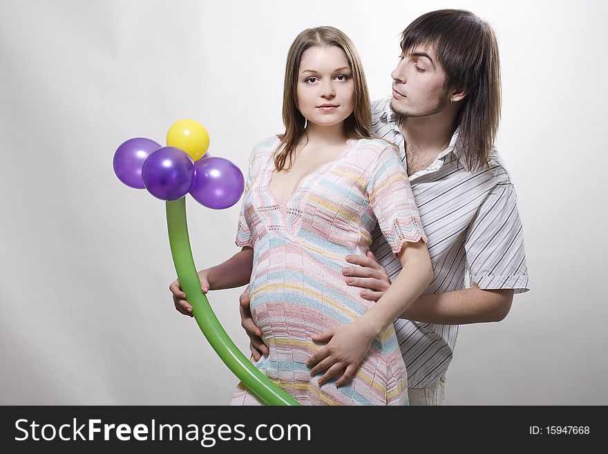 Happy flying pregnant couple holding balloon. Happy flying pregnant couple holding balloon