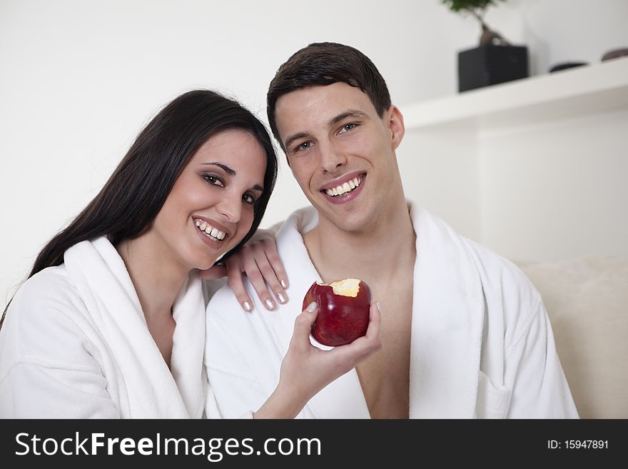 Sexy young smiling couple is having morning together in the appartment, having healthy breakfast, eating an apple. Sexy young smiling couple is having morning together in the appartment, having healthy breakfast, eating an apple