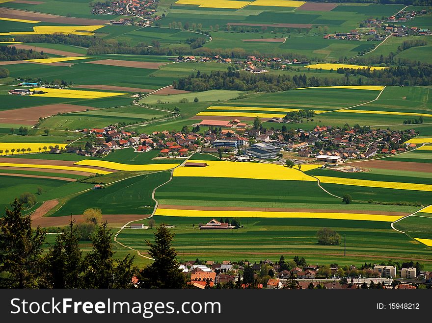 Fontaines village in the middle of Ruz Valley surrounded by fezlds and farms, Cernier city is at foreground and just behind wa can see Engollon aglomeration